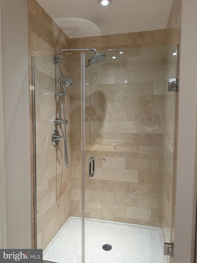 bathroom with tile patterned floors, double sink vanity, and a tile shower