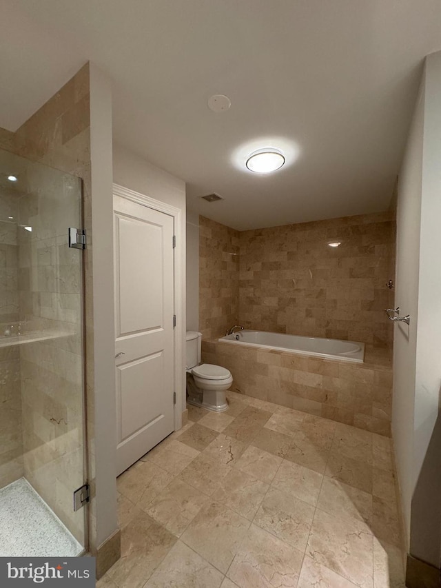 bathroom featuring toilet and separate shower and tub