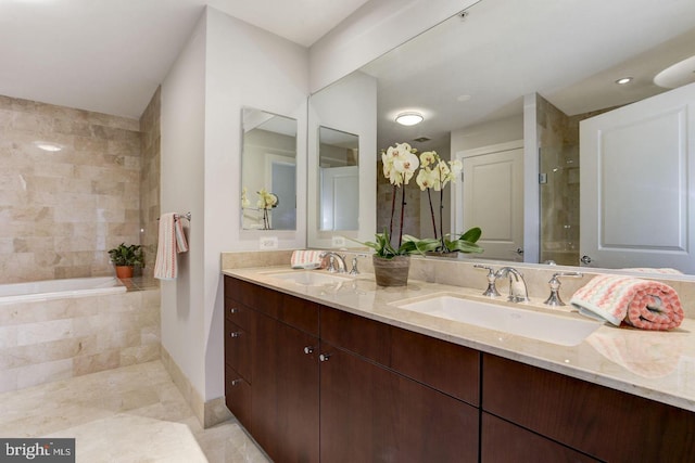 bathroom with vanity and tiled bath