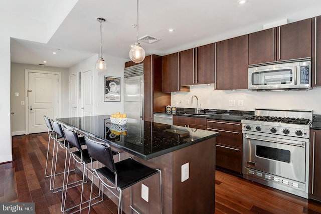 kitchen with high quality appliances, a kitchen bar, sink, and a kitchen island