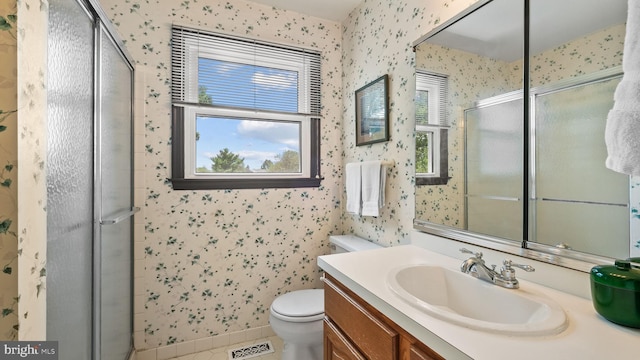 bathroom with vanity, toilet, tile patterned flooring, and an enclosed shower