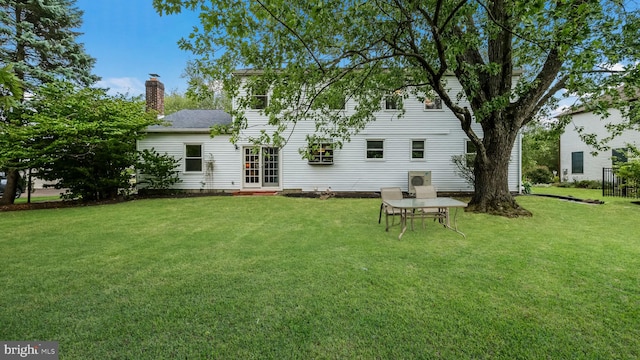 rear view of property with a yard