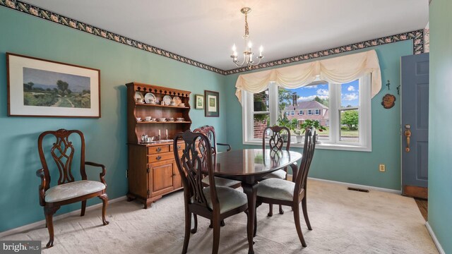 carpeted dining room with a notable chandelier