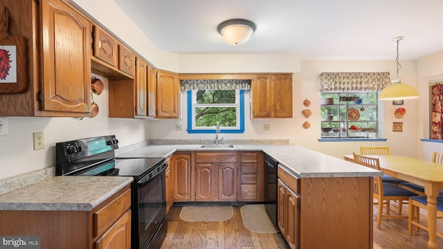 kitchen featuring black appliances, sink, kitchen peninsula, pendant lighting, and wood-type flooring