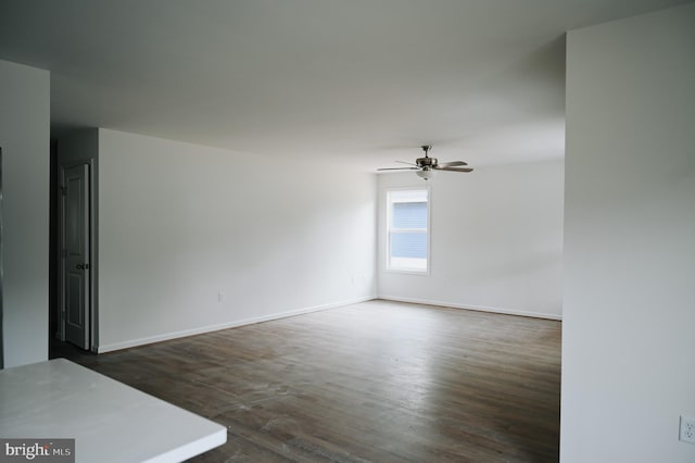 unfurnished room featuring ceiling fan and dark wood-type flooring