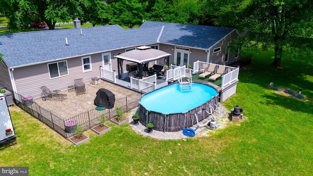 rear view of house featuring a gazebo, a swimming pool side deck, and a lawn