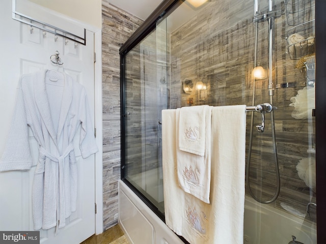 bathroom featuring combined bath / shower with glass door