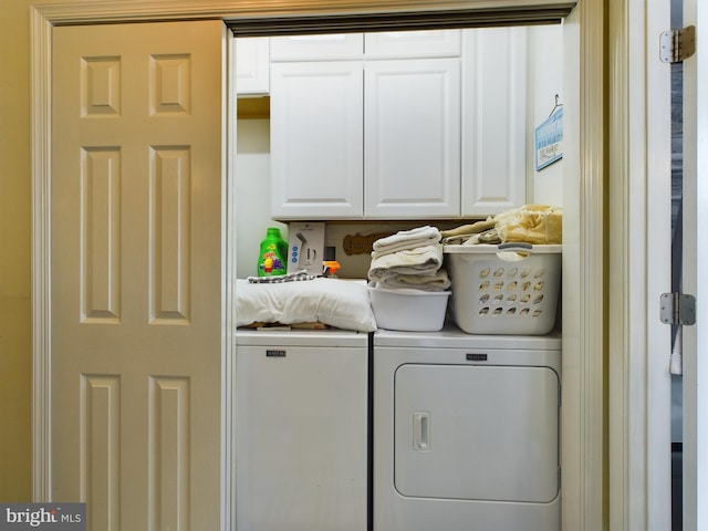 laundry area with independent washer and dryer and cabinets