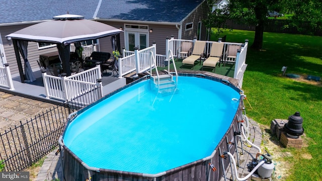 view of pool with a gazebo, french doors, and a yard