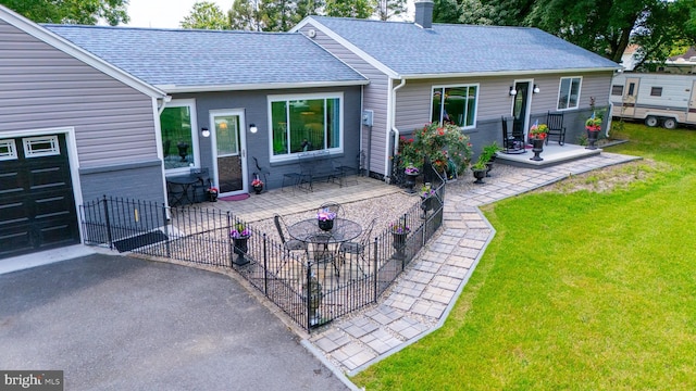 rear view of property featuring a patio and a lawn