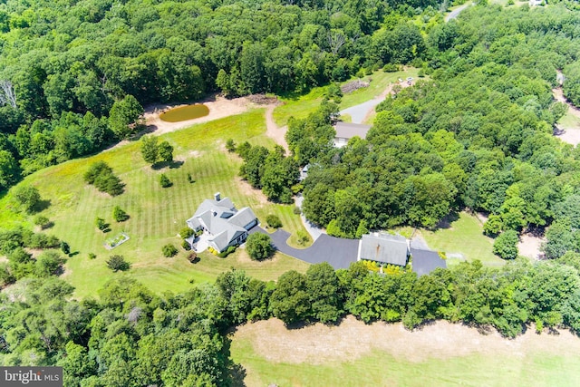 birds eye view of property featuring a wooded view