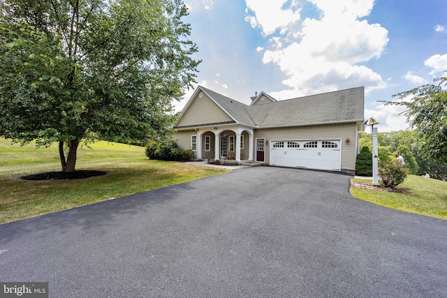 view of front facade with aphalt driveway, a front yard, and a garage