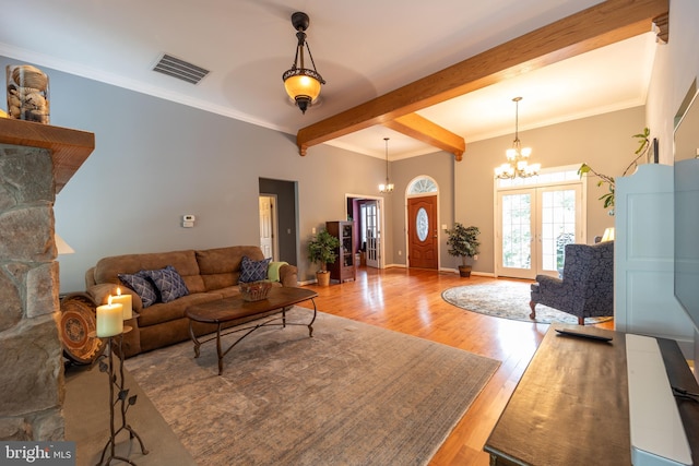 living room featuring beamed ceiling, a chandelier, ornamental molding, and hardwood / wood-style flooring