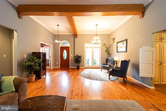 entrance foyer with a wealth of natural light, an inviting chandelier, beamed ceiling, and light wood-type flooring