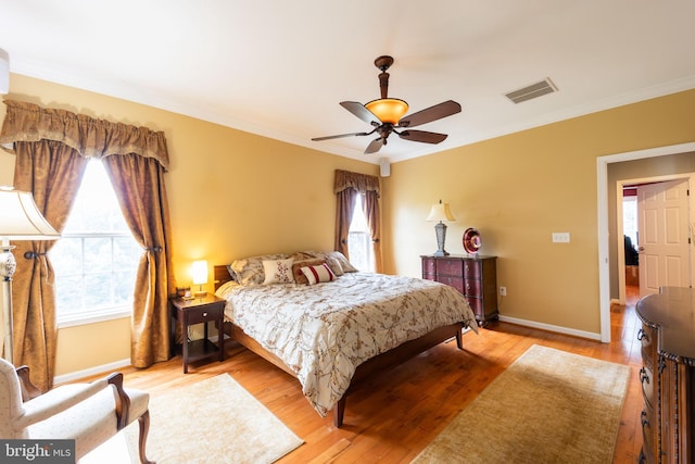 bedroom featuring ceiling fan, crown molding, and light hardwood / wood-style flooring