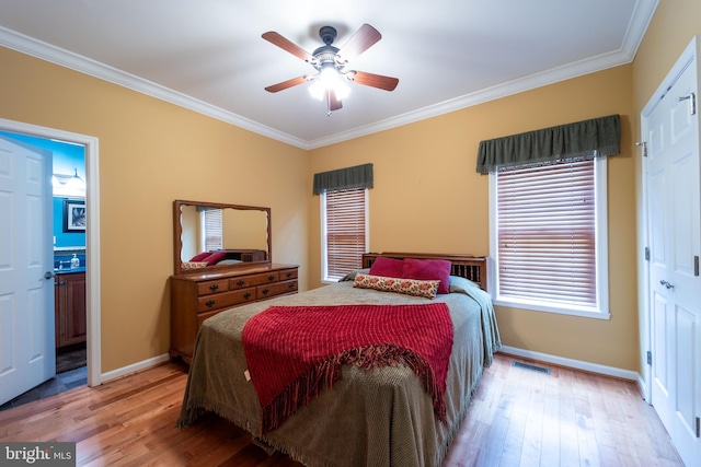 bedroom with ceiling fan, light hardwood / wood-style flooring, crown molding, and ensuite bathroom