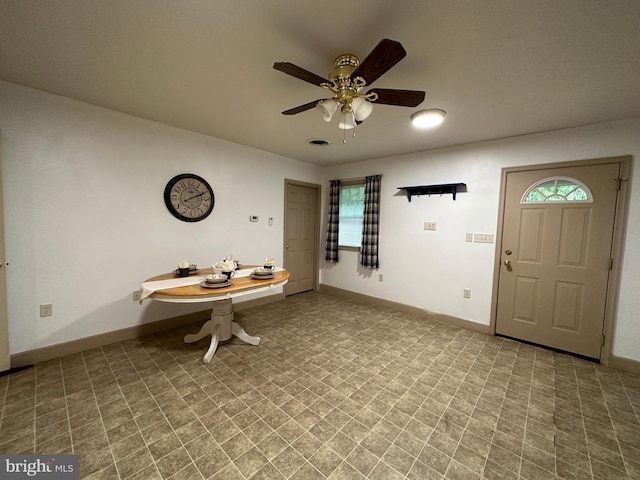 unfurnished dining area with ceiling fan and tile patterned flooring