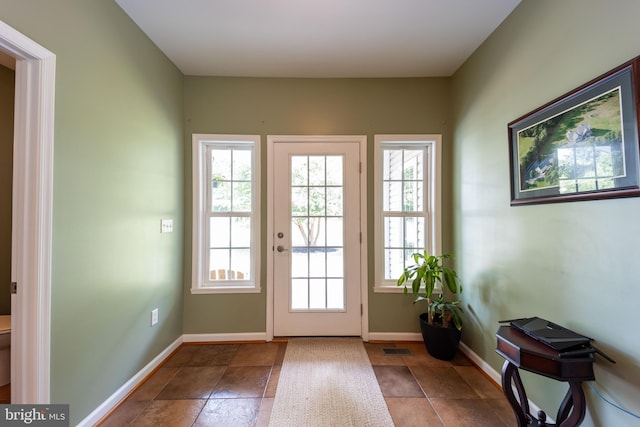 doorway to outside with tile patterned flooring