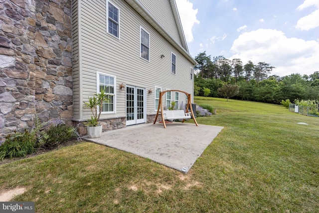 rear view of house with a patio, french doors, and a yard