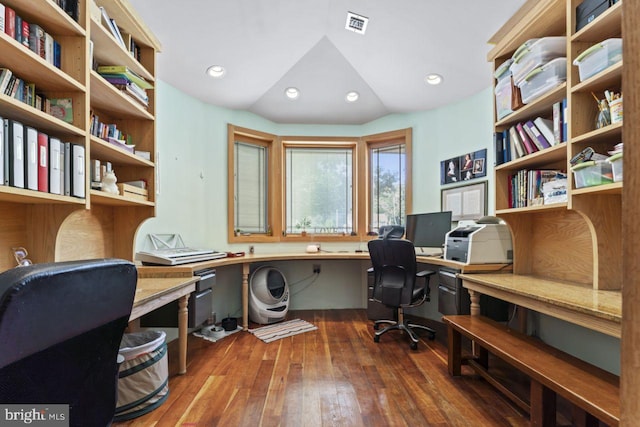 office space featuring vaulted ceiling, built in desk, and hardwood / wood-style floors