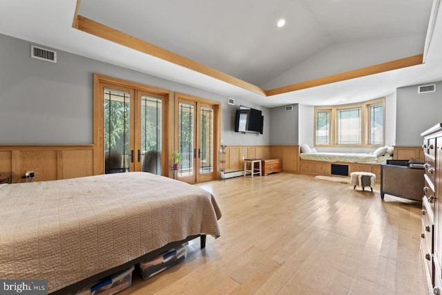 bedroom featuring lofted ceiling, light hardwood / wood-style flooring, french doors, a baseboard radiator, and a raised ceiling