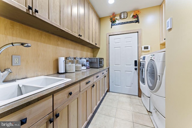 laundry area featuring sink, cabinets, washer and clothes dryer, and light tile patterned floors