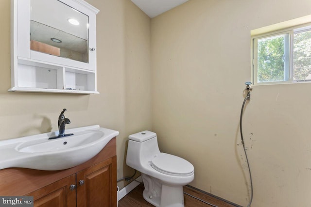 bathroom with hardwood / wood-style floors, toilet, and vanity