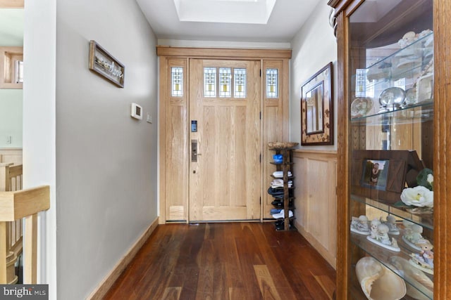 foyer entrance featuring dark hardwood / wood-style floors and a skylight