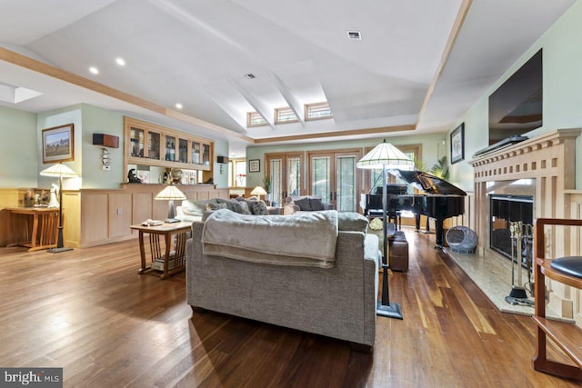 living room featuring lofted ceiling, hardwood / wood-style flooring, and a high end fireplace