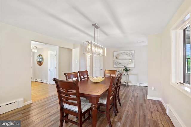 dining room featuring baseboard heating and wood-type flooring