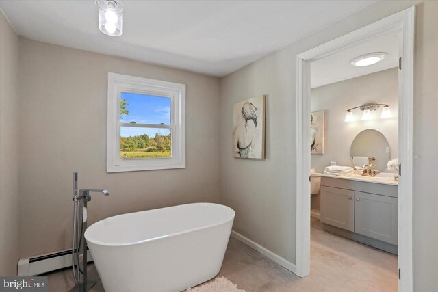 bathroom featuring vanity, a bath, and a baseboard radiator