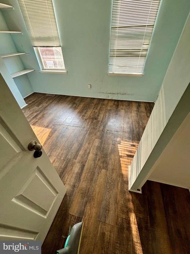 unfurnished room with dark hardwood / wood-style flooring