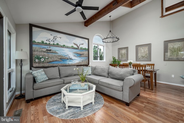 living room with lofted ceiling with beams, wood-type flooring, and ceiling fan with notable chandelier