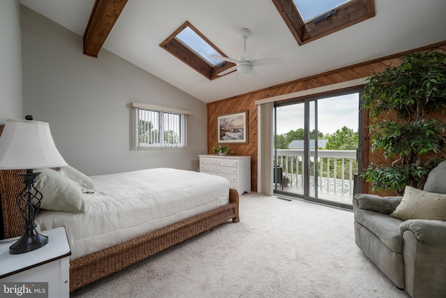 bedroom featuring access to exterior, vaulted ceiling with skylight, multiple windows, and ceiling fan