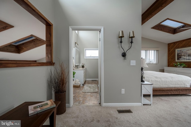 bedroom with light carpet and vaulted ceiling with skylight