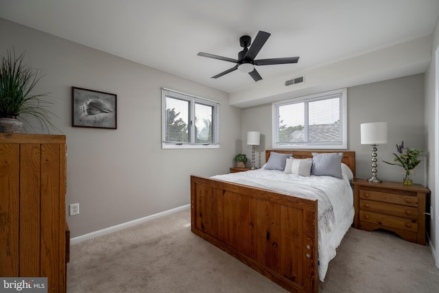 bedroom featuring light carpet, multiple windows, and ceiling fan