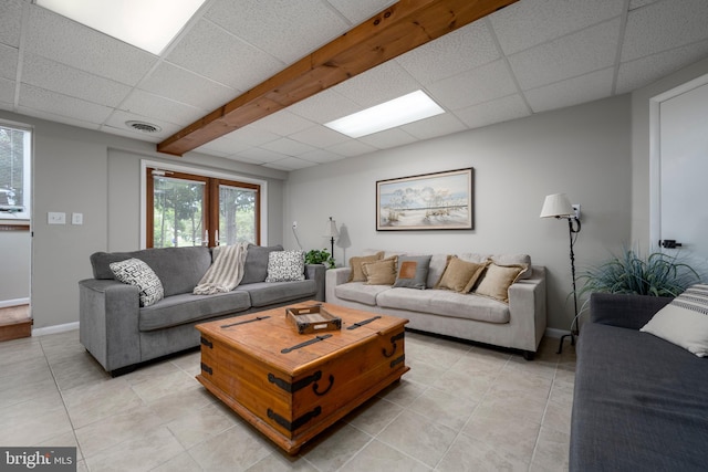 living room featuring french doors, light tile patterned flooring, and a paneled ceiling