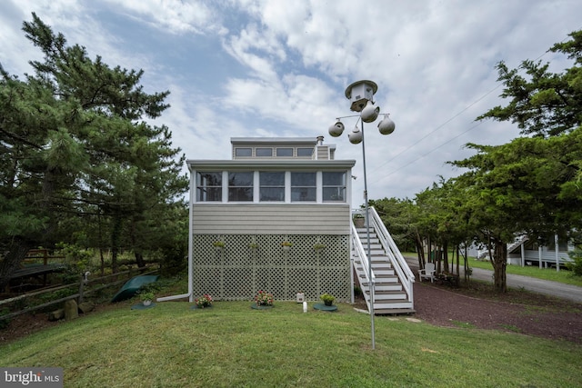 rear view of property with a yard and a sunroom