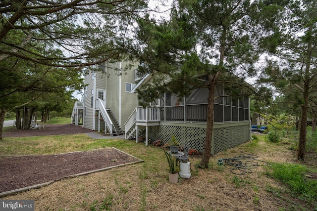 view of property exterior featuring a lawn and a sunroom