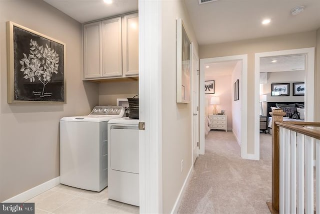 washroom with cabinets, light carpet, and washing machine and clothes dryer