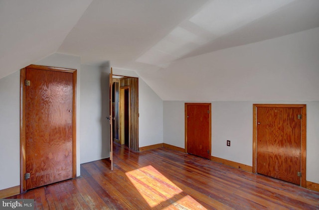 bonus room with hardwood / wood-style flooring and vaulted ceiling