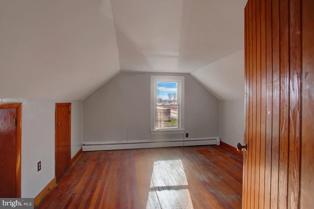 additional living space featuring baseboard heating, lofted ceiling, and dark hardwood / wood-style floors