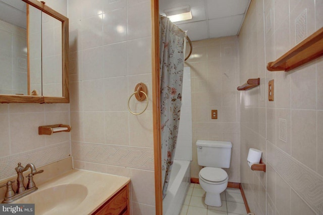 full bathroom with tile patterned floors, toilet, tile walls, vanity, and shower / bath combo