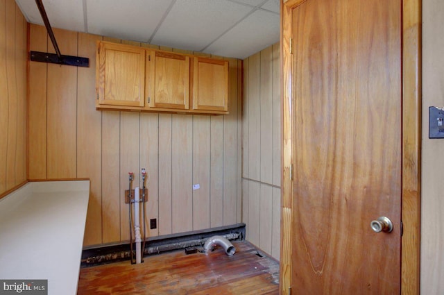 laundry area with wood walls