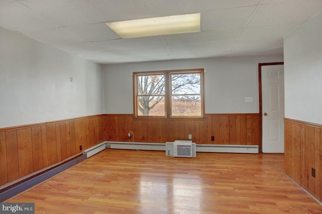 unfurnished room featuring light hardwood / wood-style floors and baseboard heating