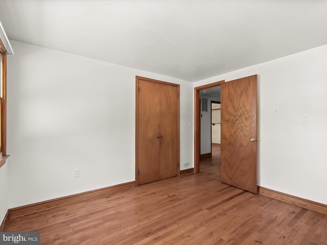 unfurnished bedroom with hardwood / wood-style floors and a closet