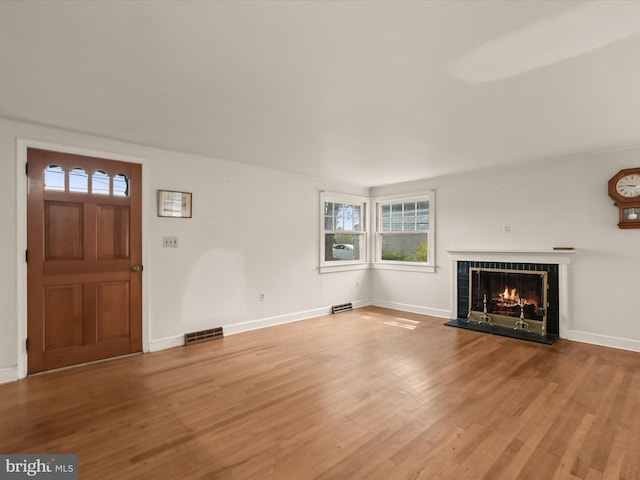 unfurnished living room featuring wood-type flooring and a fireplace