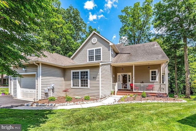 view of front property with a garage, covered porch, and a front lawn