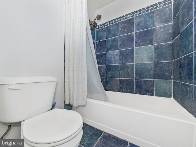 bathroom featuring shower / bath combo with shower curtain, toilet, and tile patterned flooring