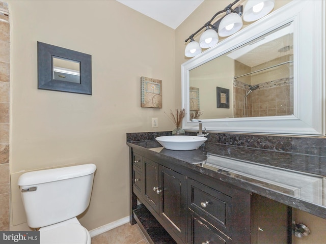 bathroom with a tile shower, vanity, toilet, and tile patterned floors